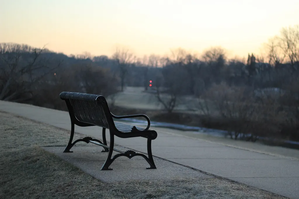 Banc vide dans un parc, à la tombée du jour